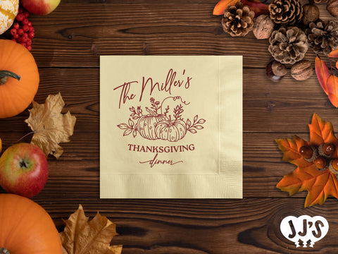 A close-up image of a custom napkin with a pumpkin patch design and personalized text, folded on a table setting.