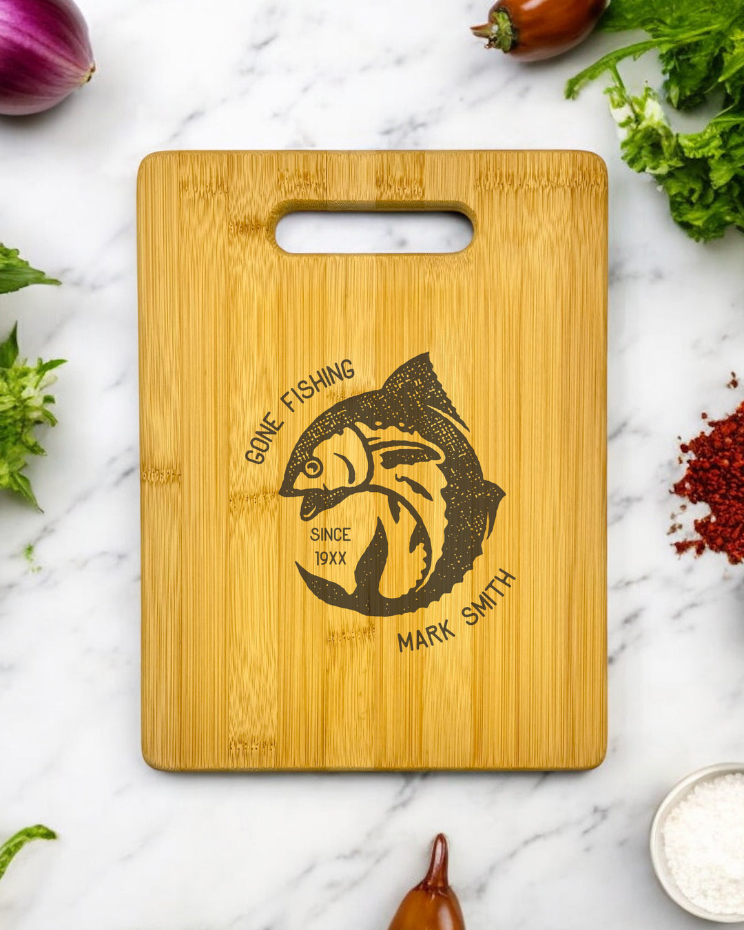 A personalized bamboo cutting board with the words "Gone Fishing" engraved on it.